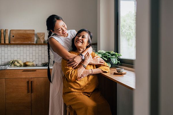 mother and daughter embracing near a window